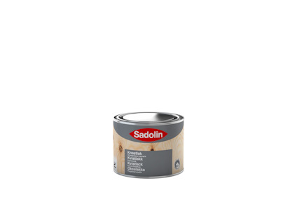 Burk med Sadolin Kvistlack, etikett i rött och grått med träfinérmönster.