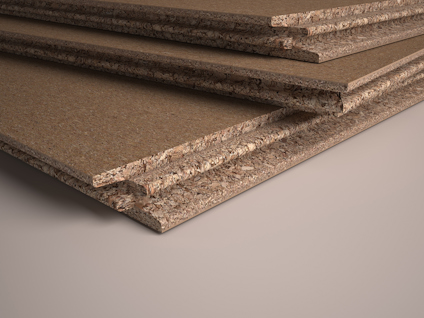 Närbild av staplade golvspånskivor i trä. Skivorna har en slät yta med spånkärna synlig vid kanterna.