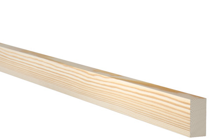 En planhyvlad trälist av furu med ljus yta och synliga ådringar sedd mot svart bakgrund.