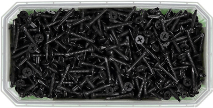 Svarta skruvar i en genomskinlig rektangulär plastbehållare.