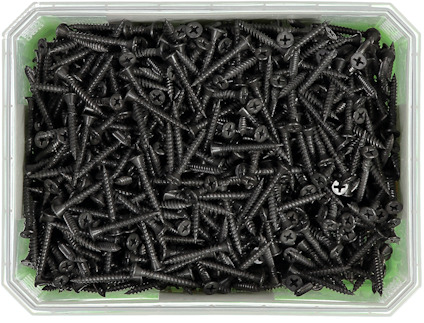 Mängd svarta skruvar i en rektangulär plastlåda med genomskinligt lock.