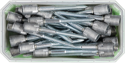 En plastlåda fylld med silverfärgade metalldubb med gängor.