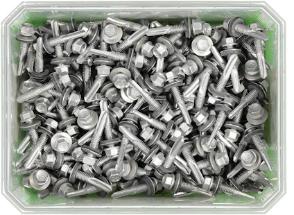 Flera silverfärgade skruvar och muttrar i en genomskinlig plastlåda.