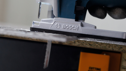 Sticksåg från Bosch i farten, sedd från sidan, sågar genom trä.