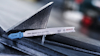 Sågblad av märket Bosch med texten "T123X PF PRO Metal thick and thin SWISS MADE" placerat mot triangulärt metallstycke.