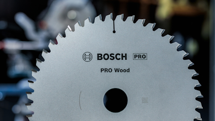 Cirkelsågblad märkt "BOSCH PRO Wood" med tandad kant, fotad mot suddig bakgrund.