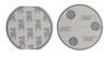 Runda objekt med 3M-klistermärken, en med tre runda magneter och en med endast klistermärke synliga.